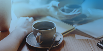 Image shows two people having a cup of coffee